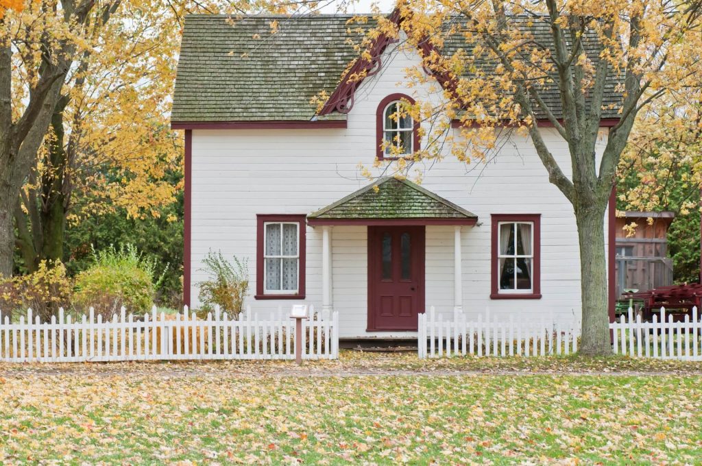 photo of a house with a white fence