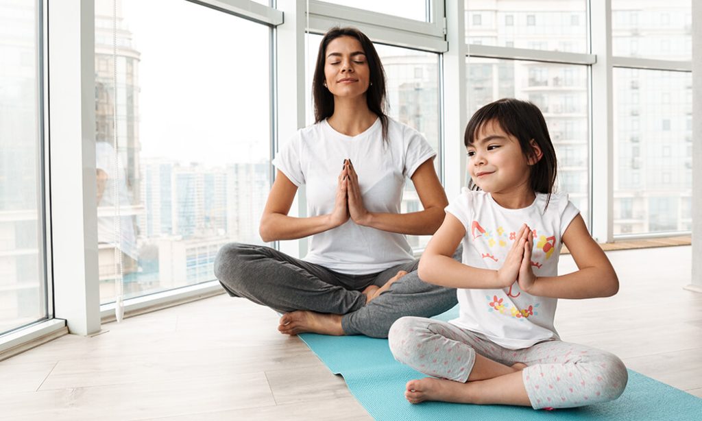 mother and daughter doing yoga