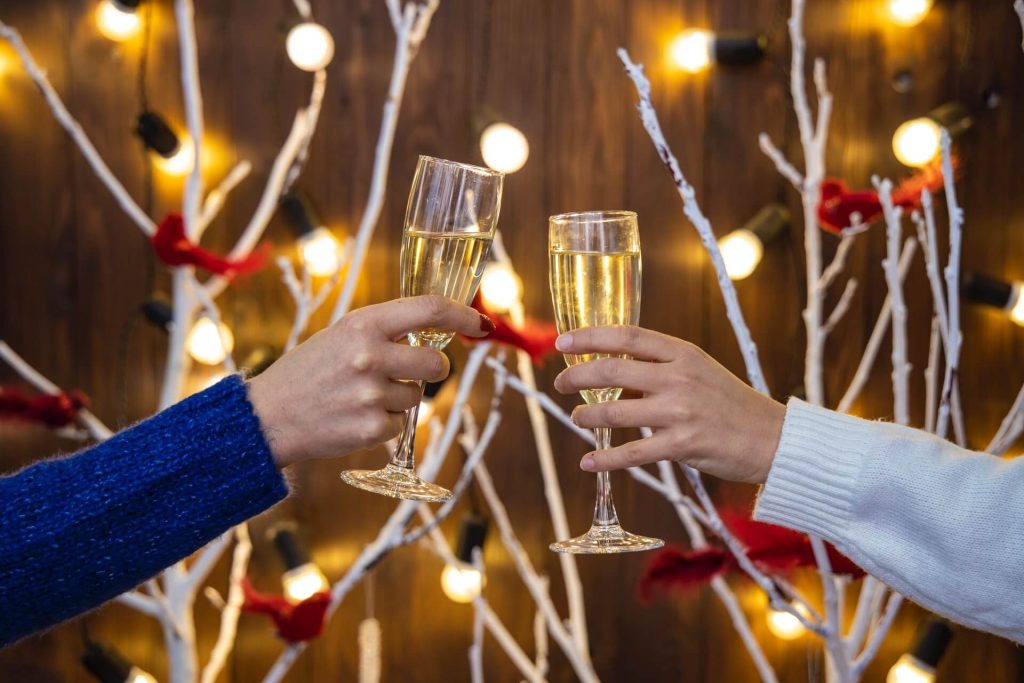 two wine glasses in cheers at a christmas party