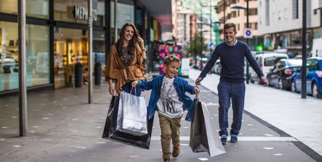 Photo of a family shopping with the sun running and carrying shopping bags