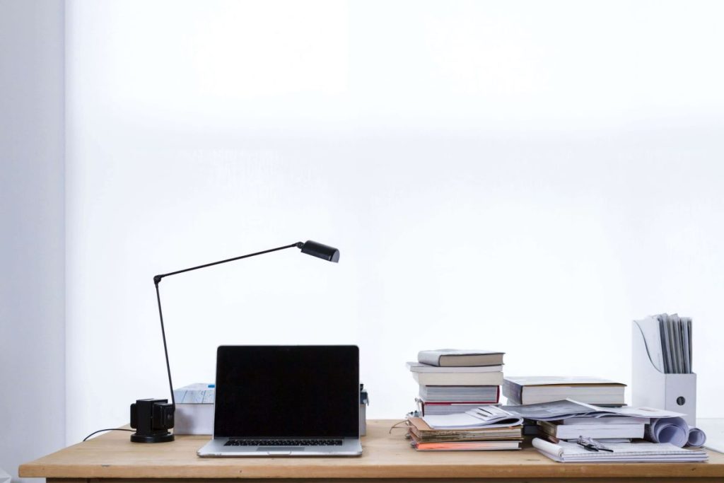 a desk with a lamp and a laptop