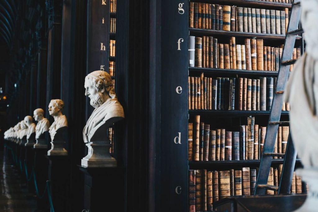 a photo of statue busts of philosophers in a library
