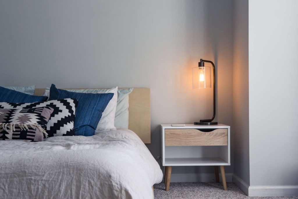 photo of a bed and bedside table with lamp