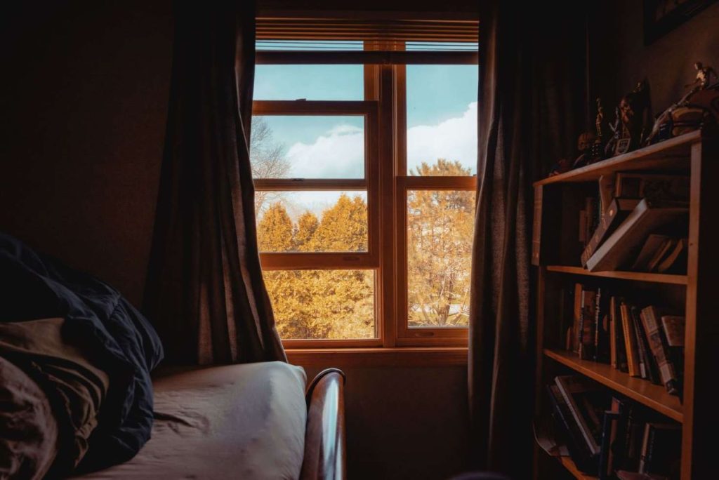 photo of a bedroom window overlooking a park