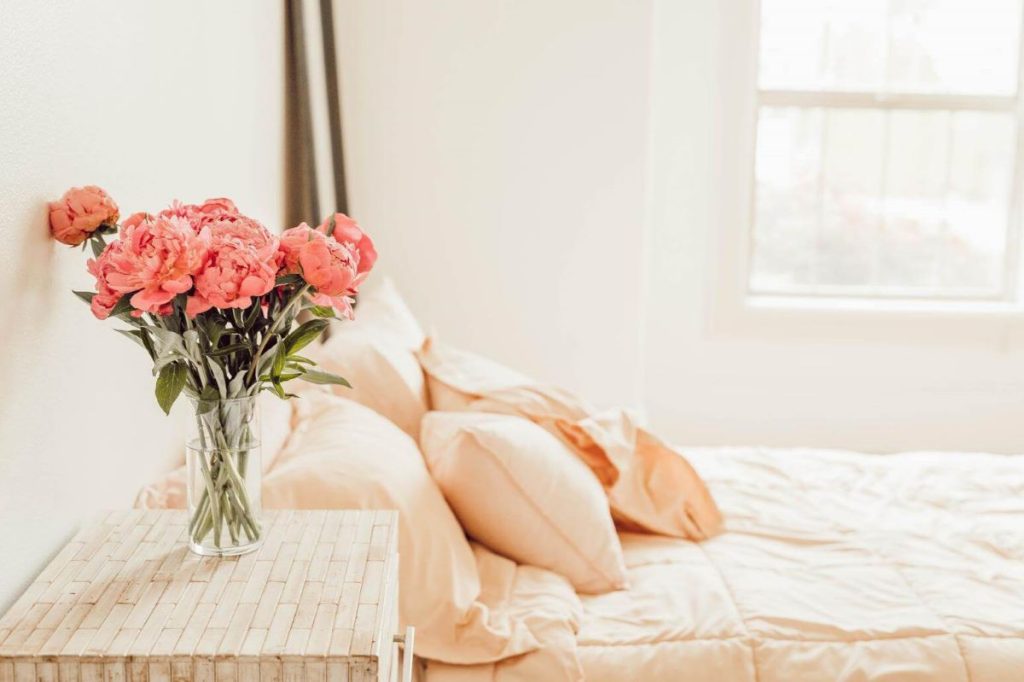 photo of a bedroom with flowers on its bedside table
