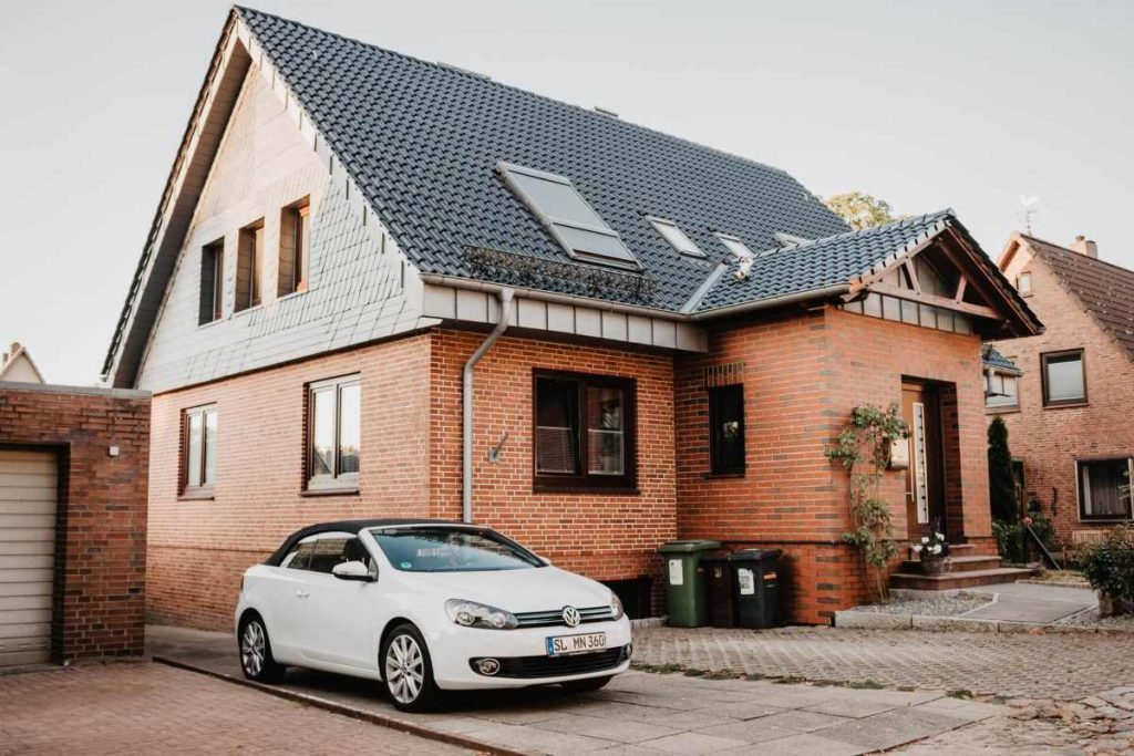 photo of a brick-house with a white Volkswagen at its driveway