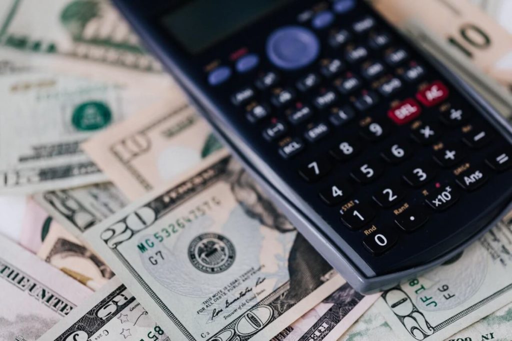 photo of a calculator on dollar bills