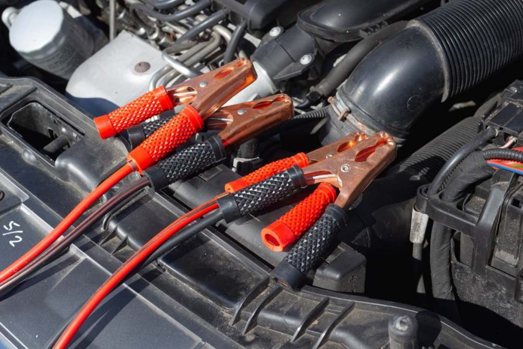 photo of a car with cables for a jump start