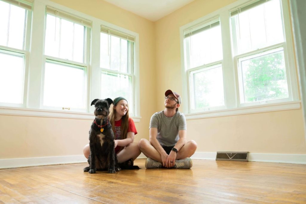 photo of a couple and their dog in an empty room