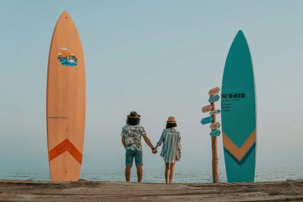 photo of a couple in the beach with two surfboard