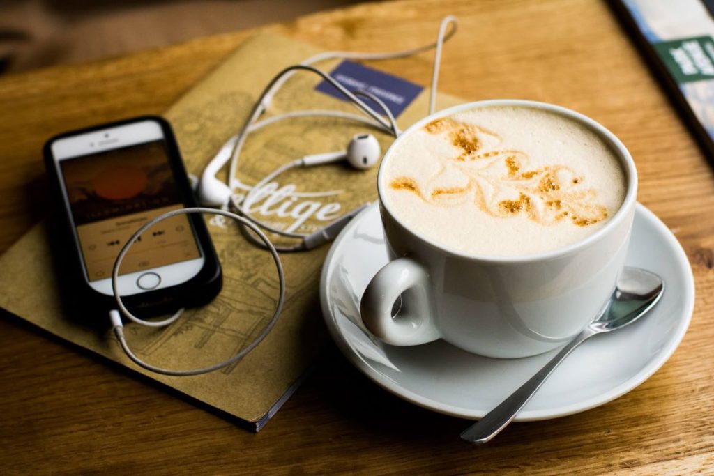 photo of a cup of coffee and a phone