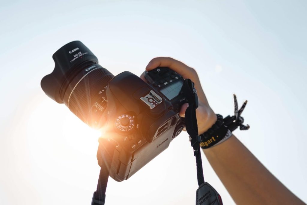 photo of a dslr camera being held against the sun