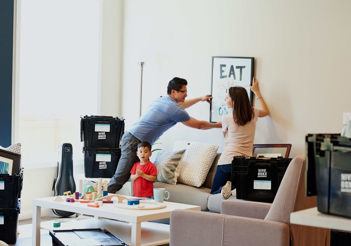 photo of a family putting a wall decor in their new home