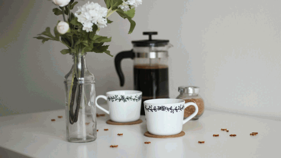 photo of a french press and coffee cups