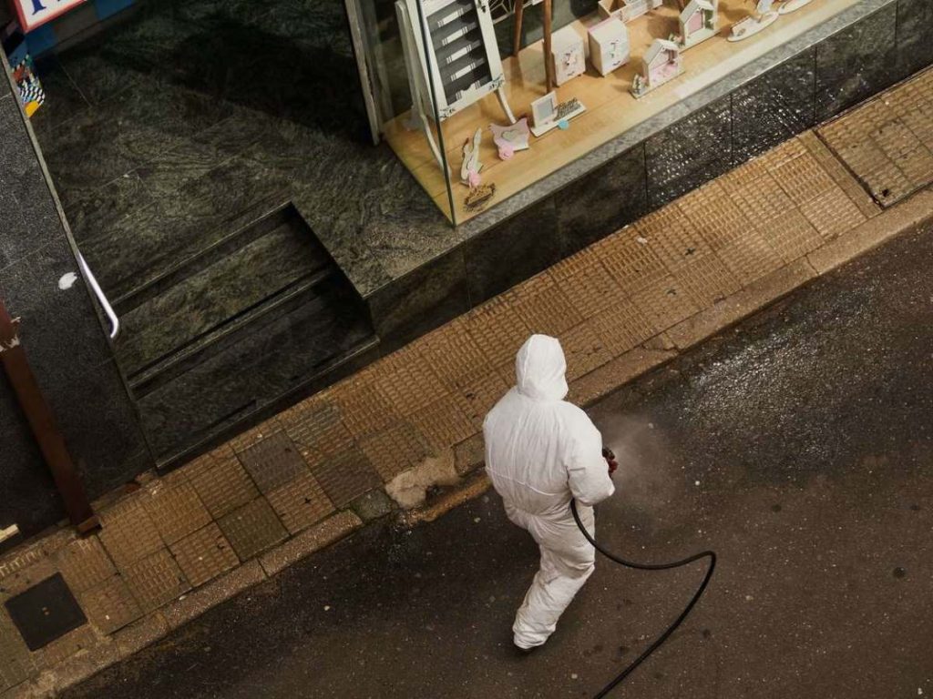 photo-of-a-frontliner-disinfecting-the-streets