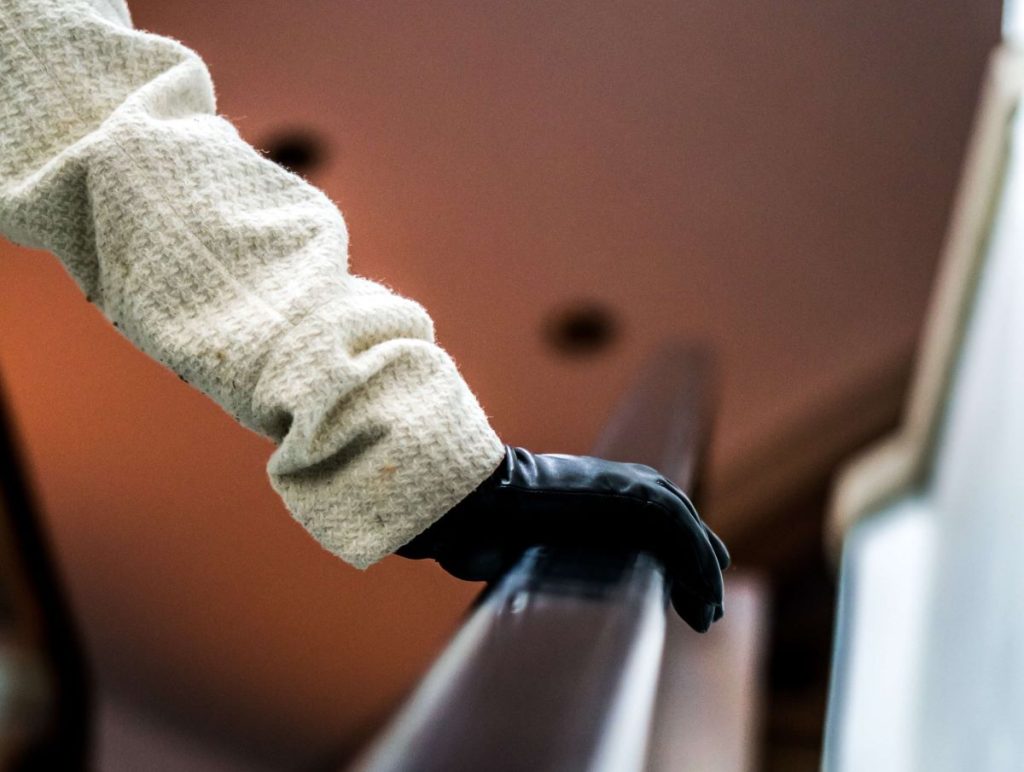 photo of a gloved hand holding an escalator railing