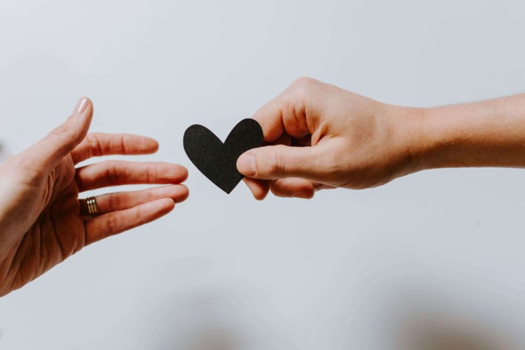 photo of a hand handing out a heart