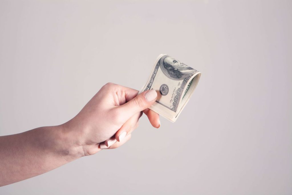 photo of a hand holding a dollar bill