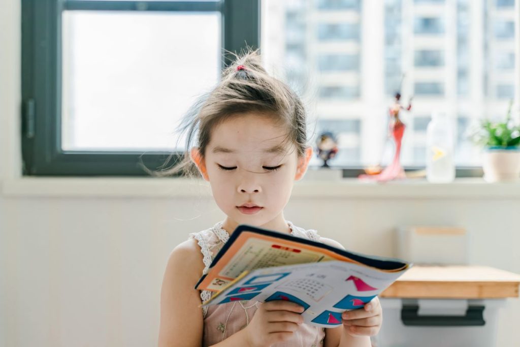 photo of a little girl reading a book