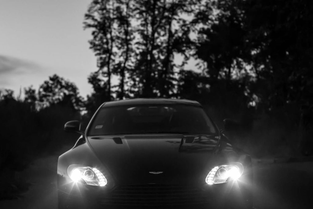 photo of a luxury car with its headlights on
