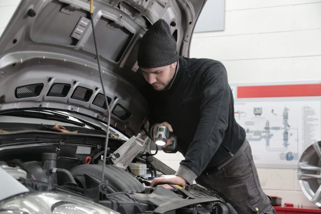 photo of a man checking a car's engine