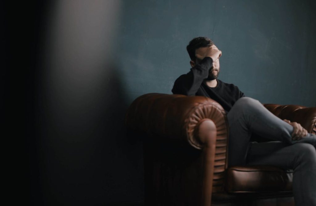 photo of a man sitting on a couch