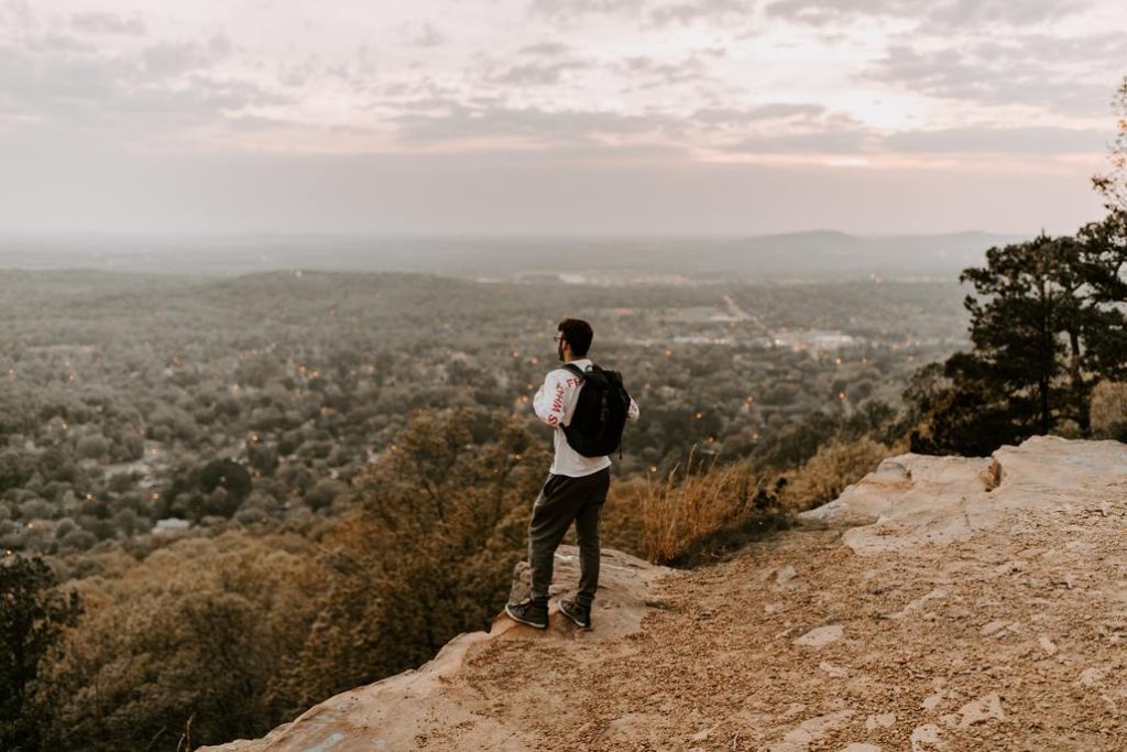 photo of a man standing at the cliff with a view