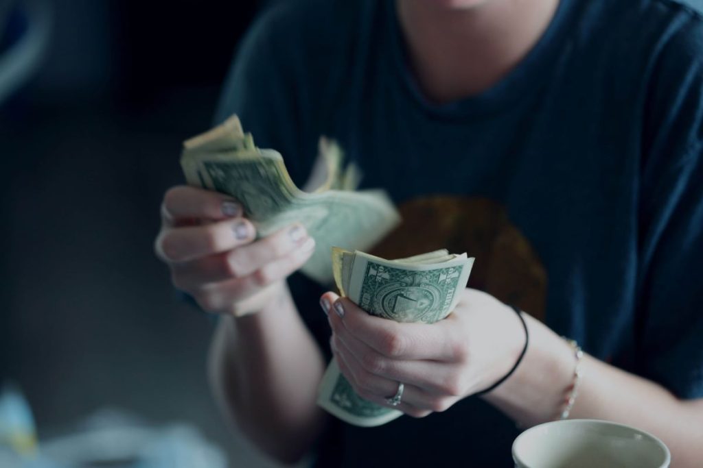 photo of a person couting dollar bills