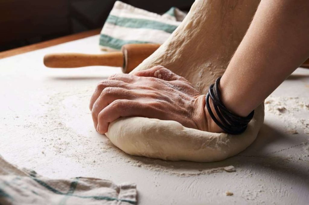 photo of a person kneading dough