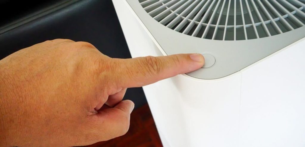 photo of a person operating an air purifier