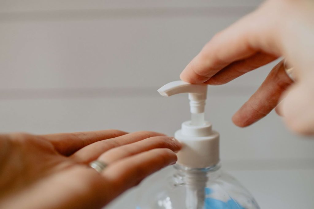 photo of a person using a hand sanitizer