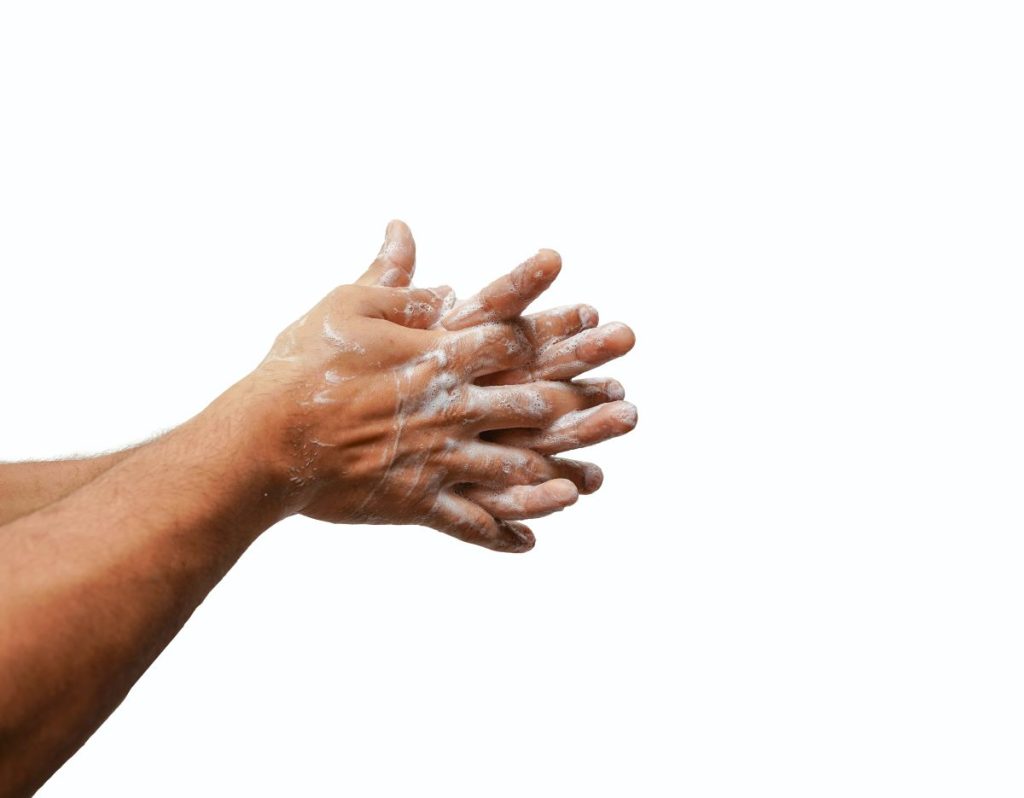 photo of a person washing their hands with soap