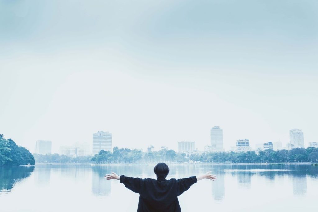 photo of a person with arms open with a view of the city