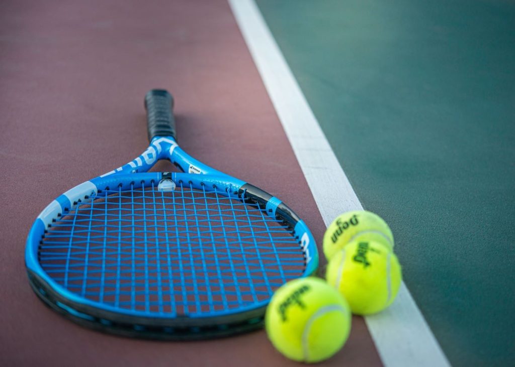 photo of a tennis racket and ball