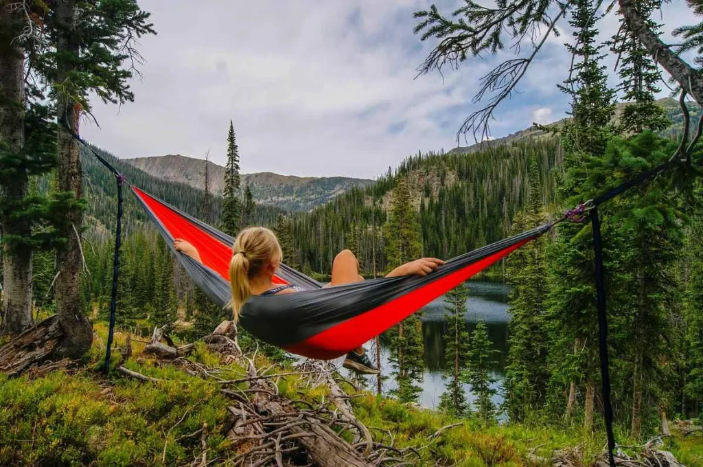 photo of a woman admiring the mountain views while on a hammock