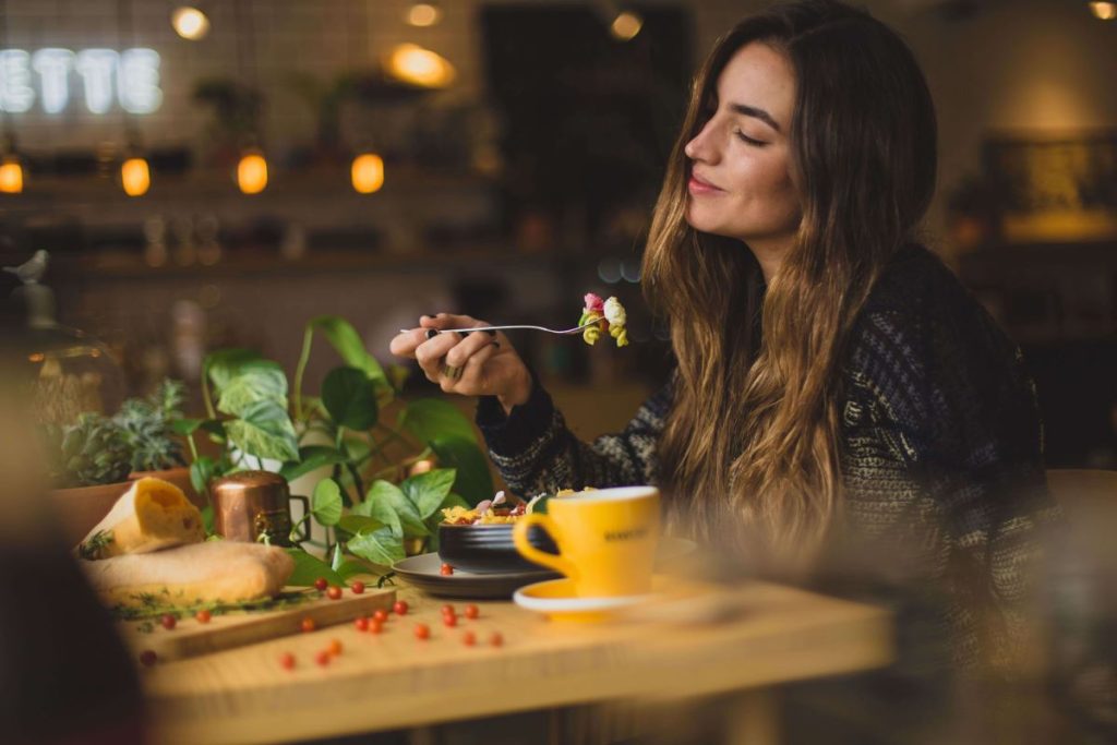 photo of a woman eating pasta