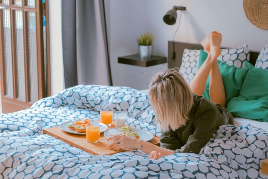 photo of a woman having a meal in bed