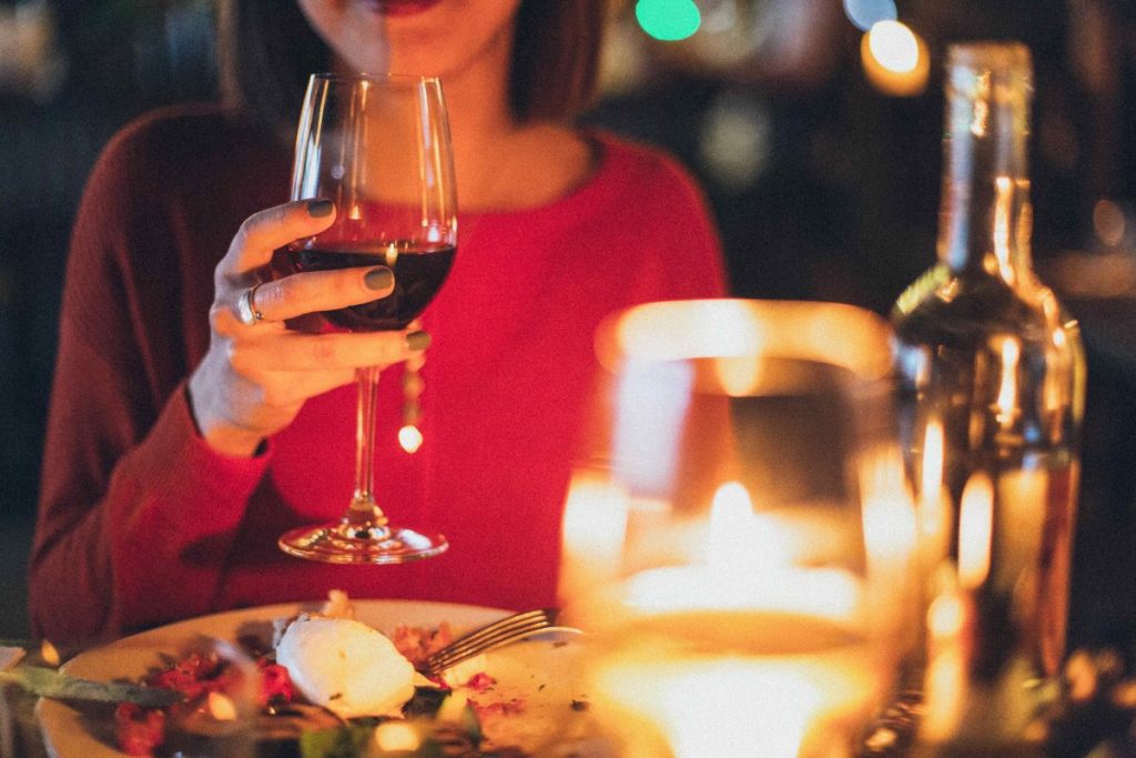 photo of a woman holding a glass of red wine