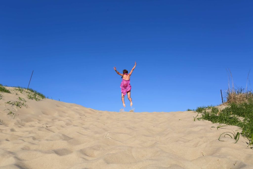 photo of a woman jumping in the beach