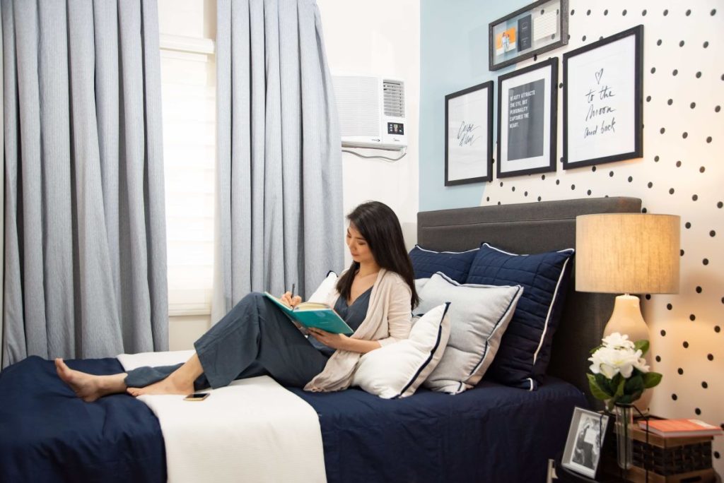 photo of a woman reading a book while in bed