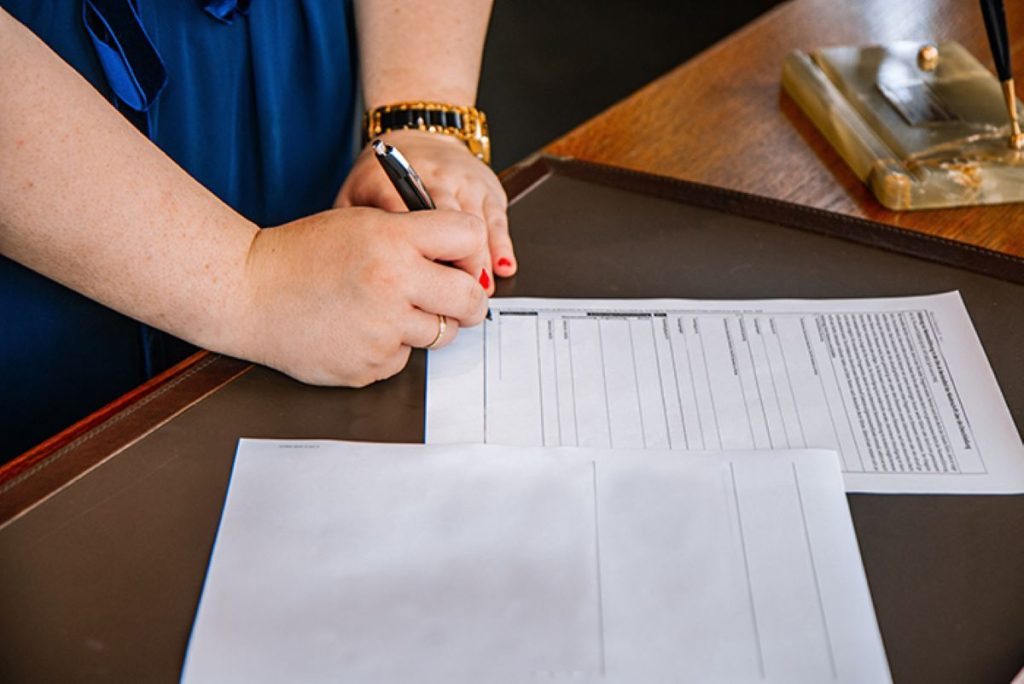 photo of a woman signing a legal document