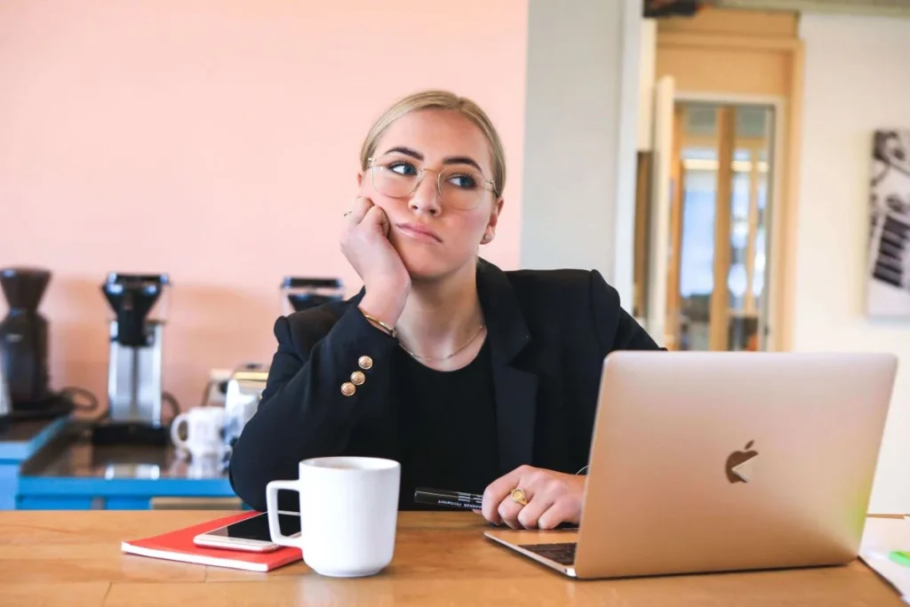 photo of a woman thinking with her laptop