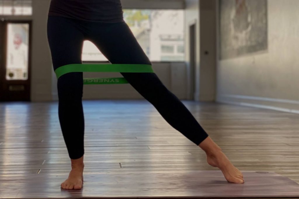 photo of a woman using a stretch band for her leg exercise