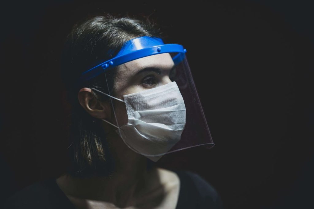 photo of a woman wearing a face mask and face shield