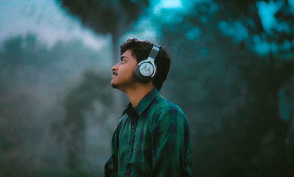 photo of a young man listening to music with his headset