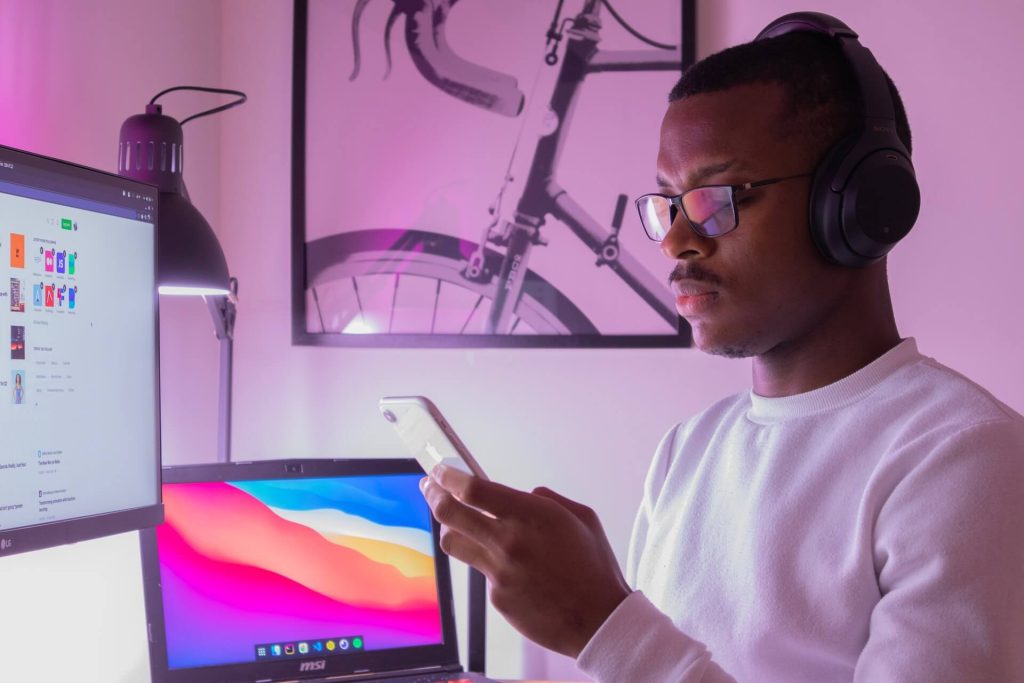 photo of a young man using his laptop and phone