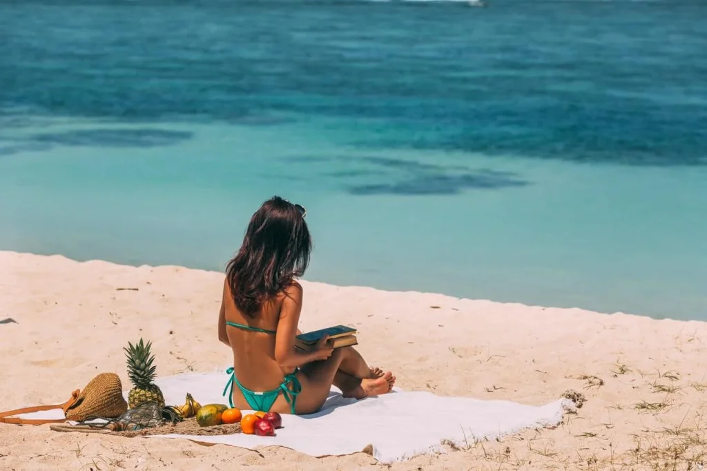 Woman sitting on a beach towel Woman-sitting-on-a-beach-towel