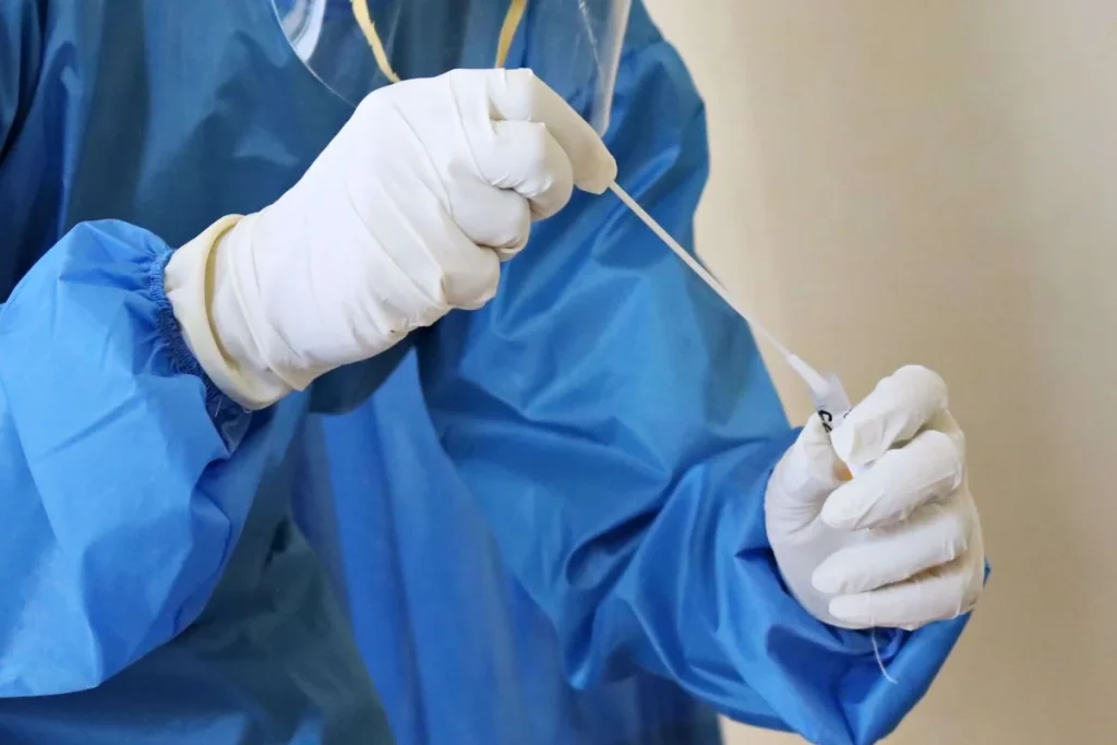 nurse holding a swab test for covid 19