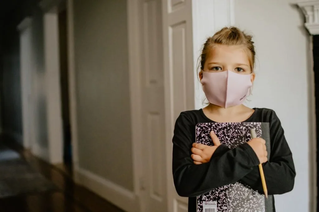 photo of a child wearing a face mask and getting ready for school