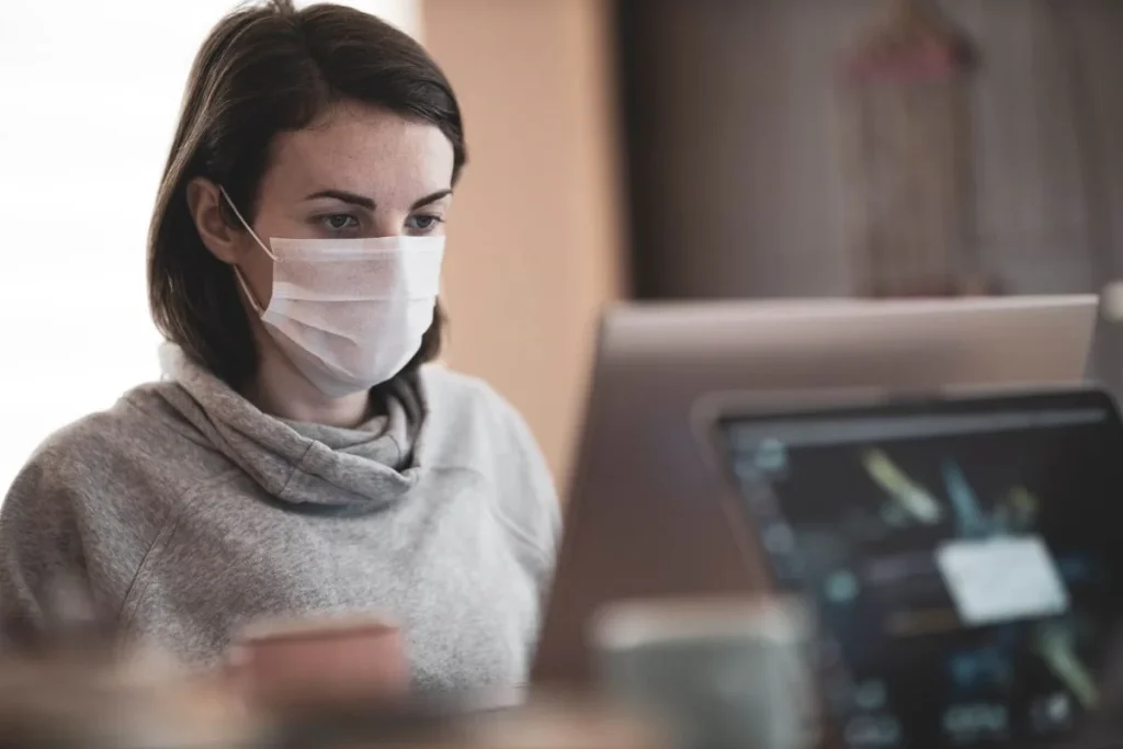 photo of a woman working while wearing a mask